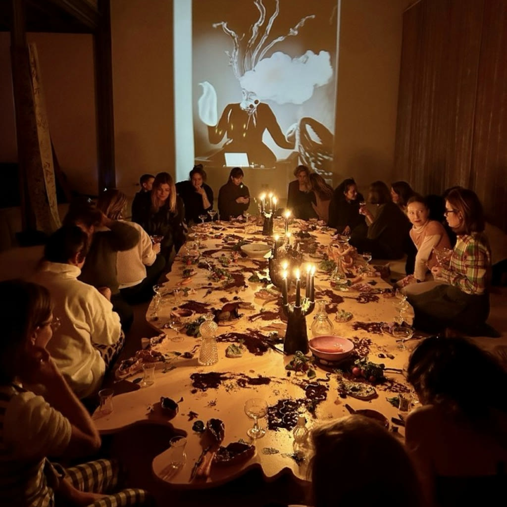 A community gathered around a long candlelit banquet table
